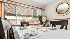 A dining area with a table set for four, including plates, napkins, and a centerpiece.