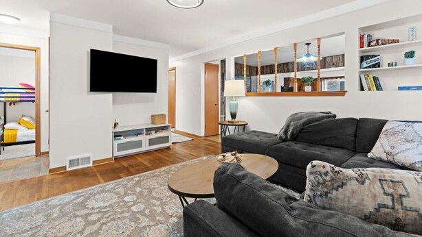 Un salon moderne avec un téléviseur à écran plat, un canapé gris et une table basse.