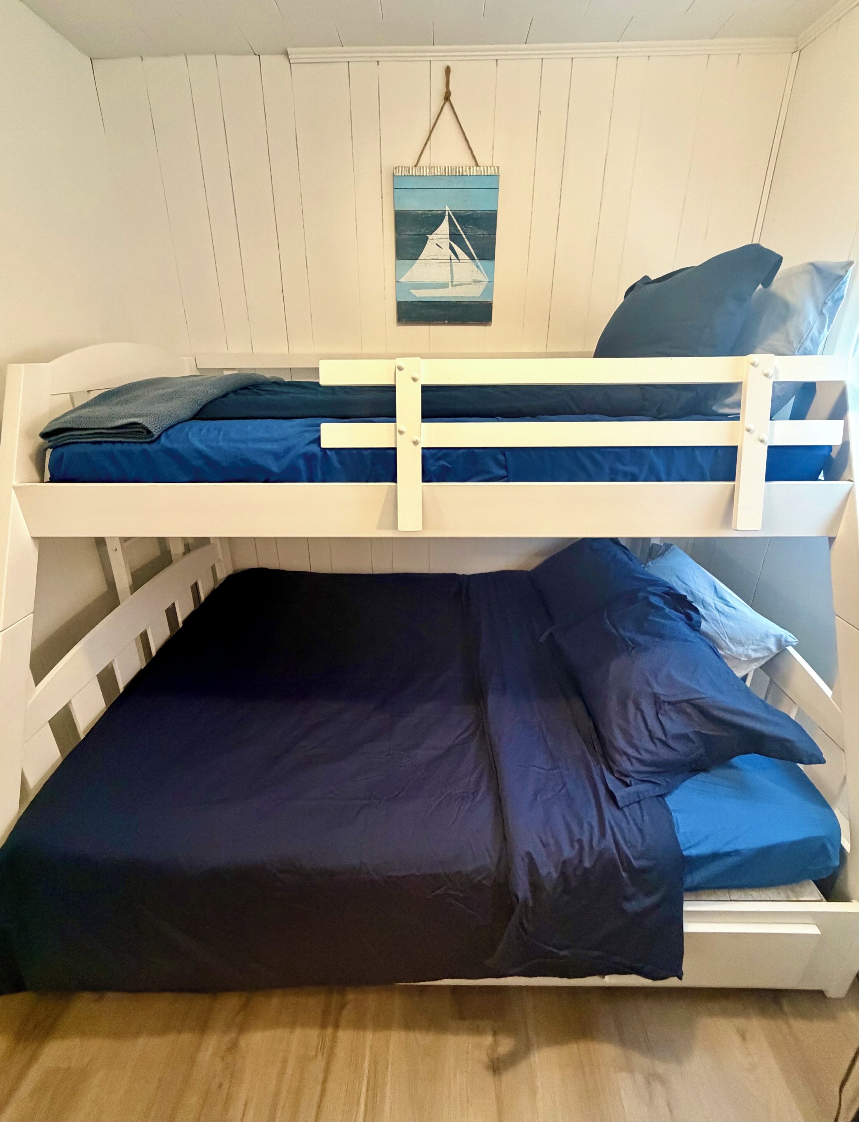A bunk bed with two levels, each with a mattress and pillows.