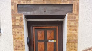 A brown door with a sign indicating surveillance.
