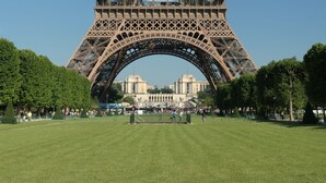 The Eiffel Tower with its intricate iron lattice structure, set against a clear blue sky.
