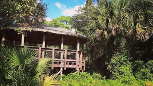 A wooden gazebo surrounded by lush greenery and trees. - Villa #8 Pompano Beach: Spacious 1BR Canal View 4 Min Walk to Beach (Pompano Beach)