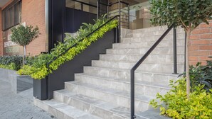 Un bâtiment moderne doté d’un escalier, d’une porte en verre et d’un mur en briques.