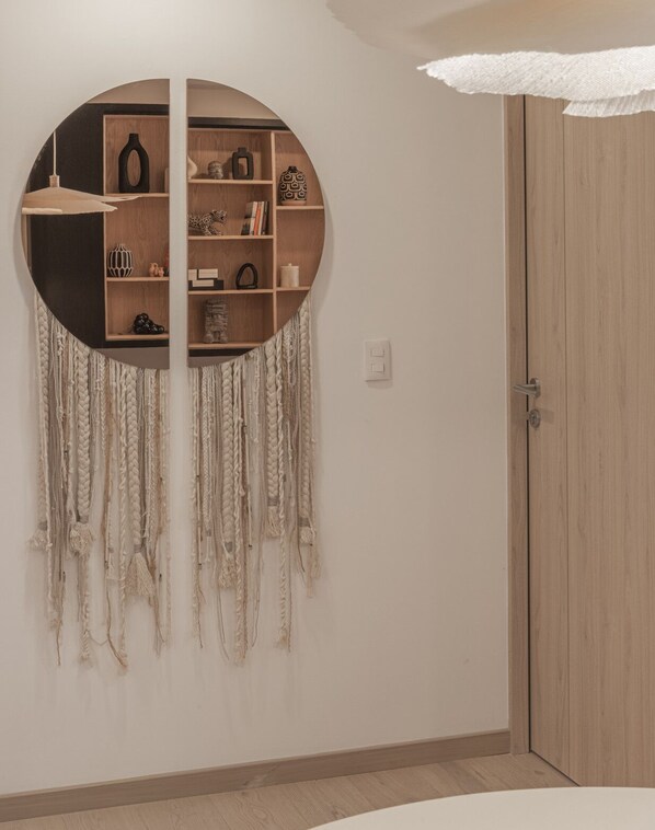 A room with a circular wall shelf, a door, and a wall-mounted macrame decoration. - Luxurious Apartment In La Condesa (Ciudad de México)