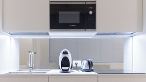 Een moderne keuken met een Bosch magnetron, een waterkoker en een spoelbak.