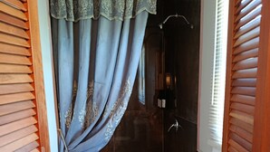 Une petite salle de bain avec une douche, des toilettes et un rideau.