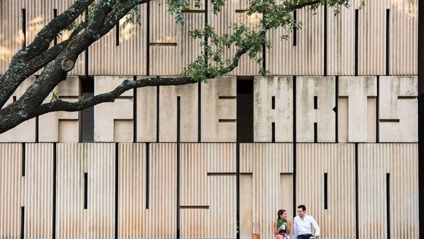 A modern building facade with vertical lines and a tree branch extending over the entrance. - Midtown Gem! Sleeps 3 Near Richmond and Montrose (Houston)