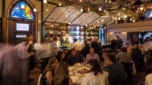 A bustling restaurant with a bar area, high ceilings, and hanging lights. - Midtown Gem! Sleeps 3 Near Richmond and Montrose (Houston)
