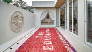Un bâtiment moderne doté d’une entrée décorative, d’un chemin bordé de fleurs et offrant une vue dégagée sur l’intérieur.