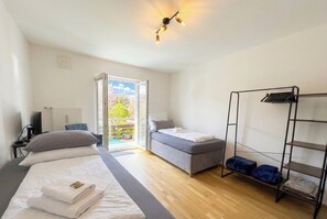 Ett rum med en säng, en soffa, en garderob och utsikt över omgivningarna.