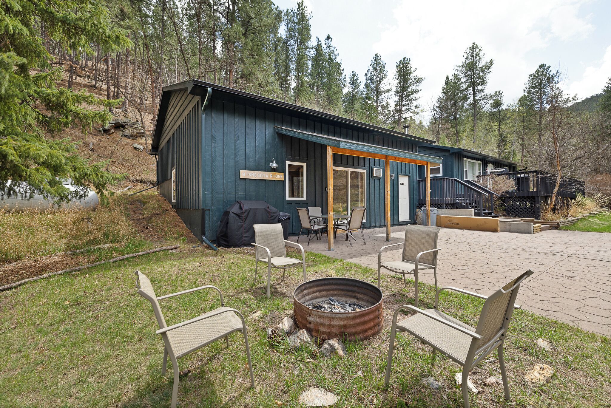 A rustic cabin with a fire pit and outdoor seating.