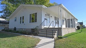A two-story house with a front porch, a visible garage door, and a small front yard.