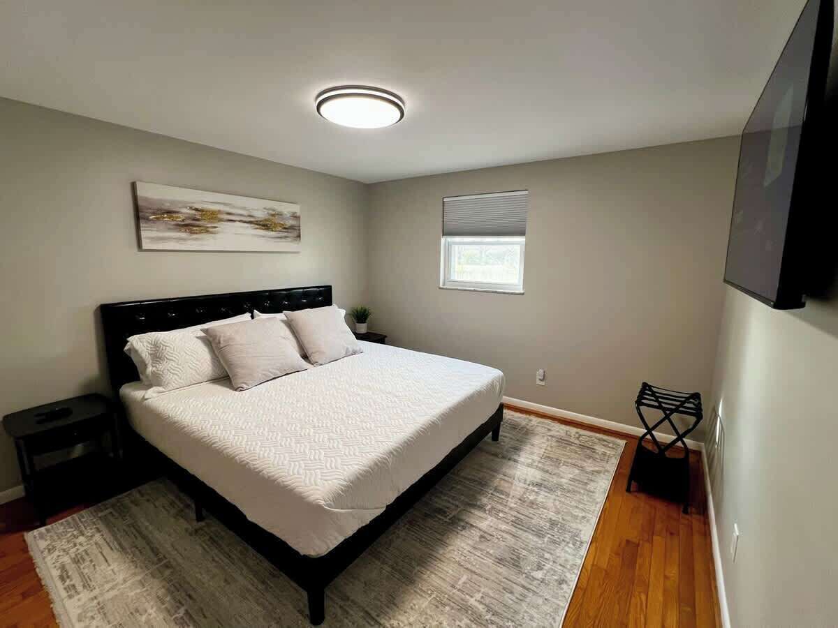 A bedroom with a bed, nightstands, a window, and a ceiling light.