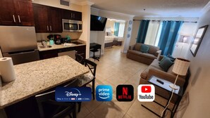 A modern kitchen with granite countertops, a built-in microwave, and a stainless steel refrigerator. - Comfortable Family Disney Orlando Universal (Kissimmee)