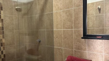 Een douche, handdoeken, zeep, toiletpapier