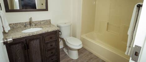 A bathroom with a sink, toilet, and bathtub.
