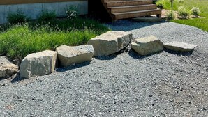 Una casa de dos pisos con un porche cubierto, una puerta principal y unos escalones que conducen a la entrada.