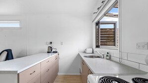 Una cocina compacta con estufa, fregadero y encimera.