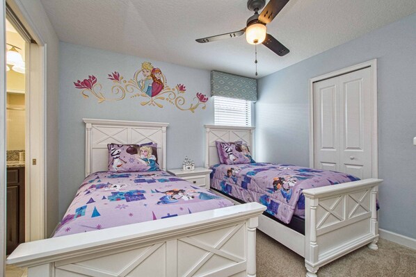 A bedroom with two beds, a ceiling fan, and a decorative wall mural. - Beautiful Home With Private Pool in Champions Gate (Davenport)