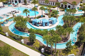 Luchtbeeld van een resort met meerdere zwembaden, lounges en palmbomen.