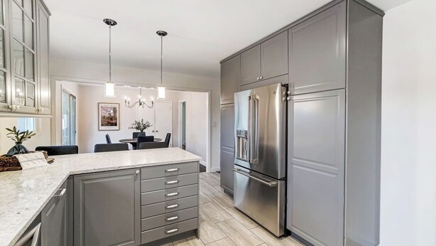 A modern kitchen with grey cabinetry, a stainless steel refrigerator, and a marble countertop. - Modern, Fully Furnished Retreat, Close to OSU Campus, Downtown and Riverside Hos (Columbus)