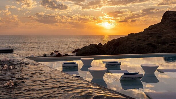 An infinity pool with lounge chairs, overlooking the ocean at sunset. - Oceanfront Penthouse for 8 • 360° Views & Jacuzzi (Los Cerritos)