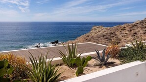 A coastal view with a wooden deck, cacti, and a sandy landscape. - Oceanfront Penthouse for 8 • 360° Views & Jacuzzi (Los Cerritos)