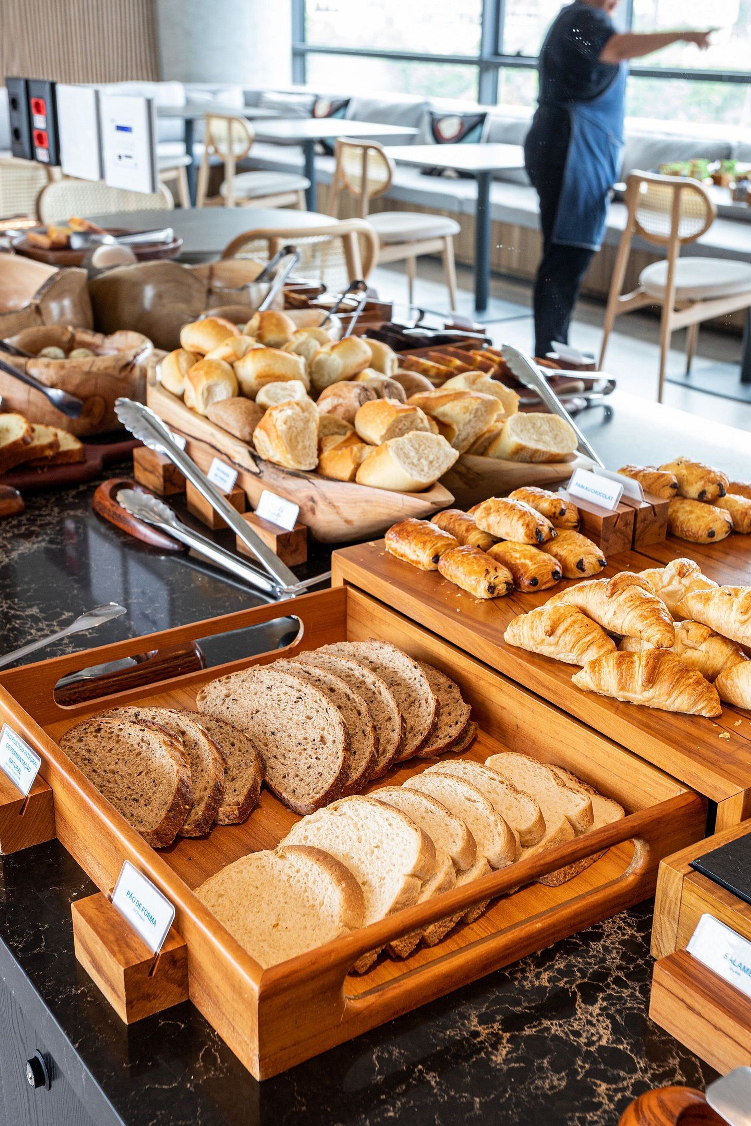 Un bufé de desayuno con panes y bollería variada.