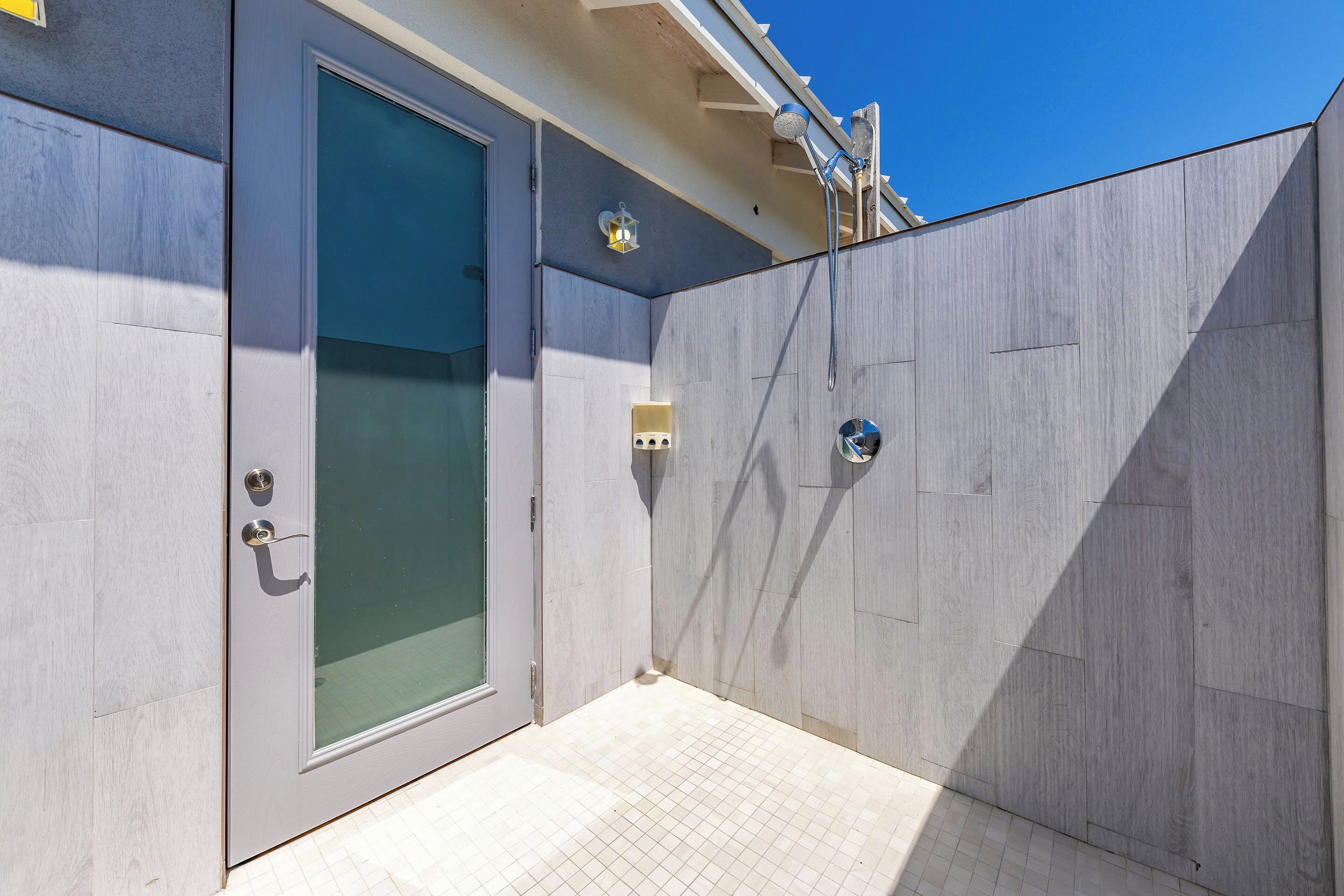 A modern bathroom with a glass door, a shower area, and a tiled floor.
