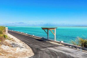A coastal road with a wooden shelter and a clear view of the turquoise sea.