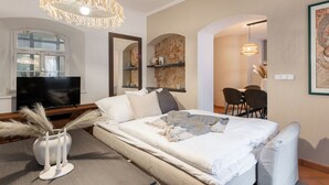Een moderne slaapkamer met een groot bed, een televisie en een zithoek.