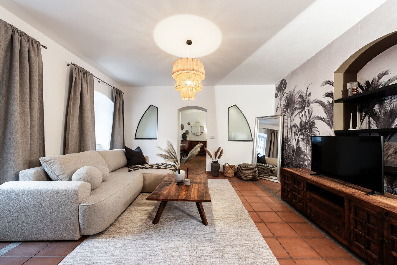 A modern living room with a sofa, coffee table, and TV stand.