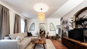 Een moderne woonkamer met een bank, salontafel en tv-meubel.