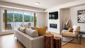 Una sala moderna con sofá, sillón y mesitas de madera.