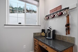 A kitchen with a window, a coffee maker, a knife block, and a sign above the knife block. - Schweitzer Mountain 3 bd Getaway (Sandpoint)