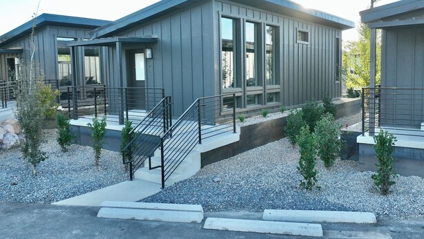 A modern building with a flat roof, large windows, and a gravel driveway. - Charming cabin with full RV resort access incl, WiFi in welcoming South Weber (South Weber)