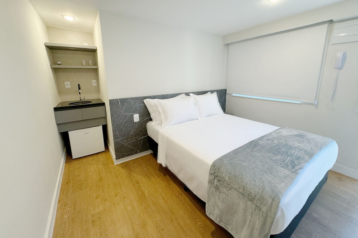 Ein gemütliches Hotelzimmer mit Bett, einer kleinen Küchenzeile und einem Badezimmer.