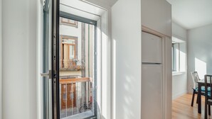A modern kitchen with a built-in oven and a dining area with a table and chairs. - Downtown Sunny Apartment by Vacationy (Porto)