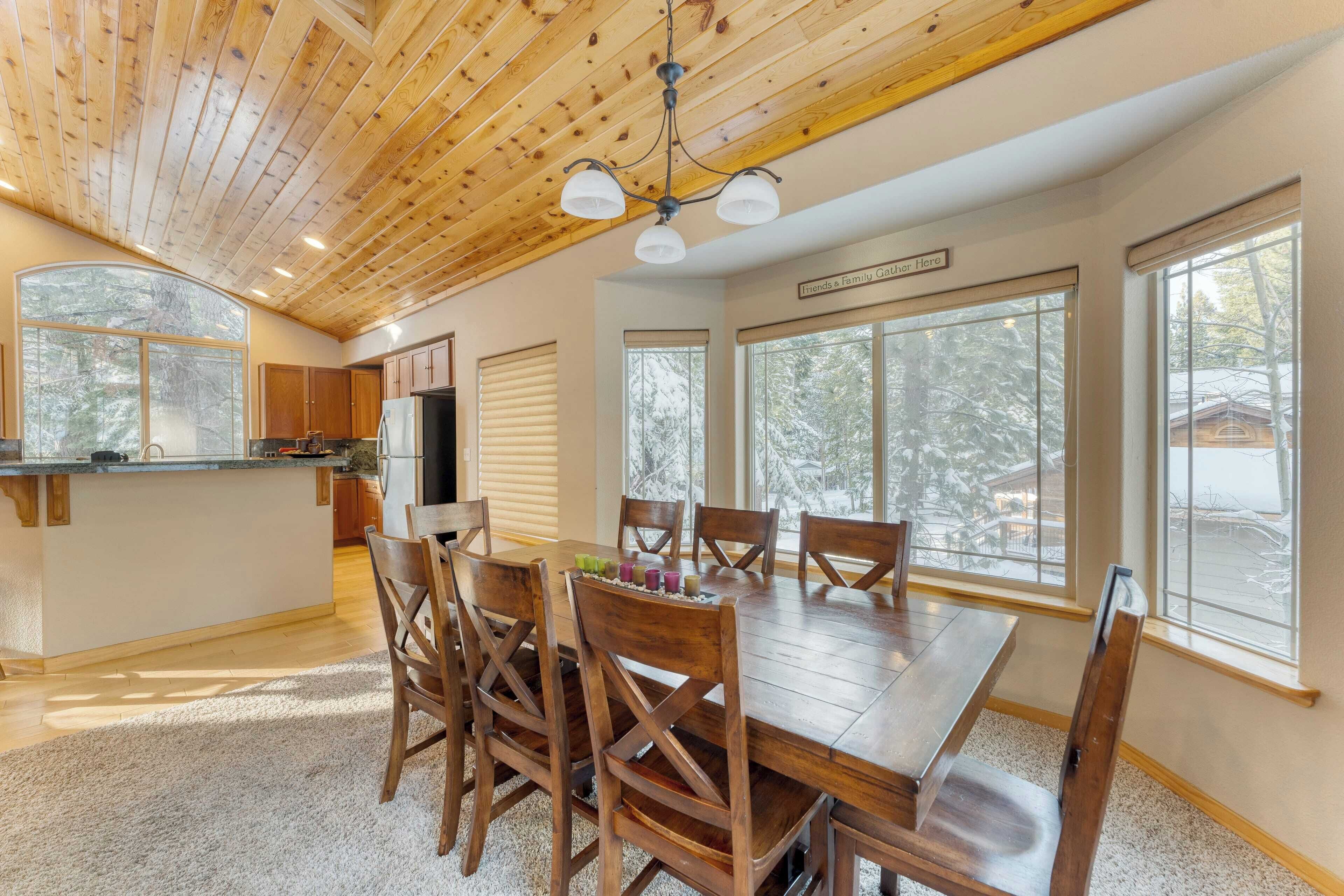 A spacious kitchen with wooden cabinets, a large island, and a dining area with a wooden table and chairs.