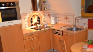 A compact kitchen with a built-in oven, a coffee maker, and a dishwasher.
