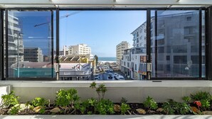 A modern building with large windows overlooking a busy street and a clear sky.