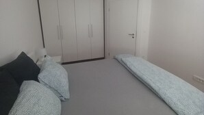A bedroom with a wardrobe, a bed, and a bedside table. - Idyllic and Charming Apartments with Terrace - Standard Two Bedroom Apartment with terrace (Preddvor)