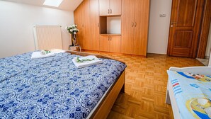 Ein Schlafzimmer mit einem großen Bett, einem Holzschrank und einer Tür.