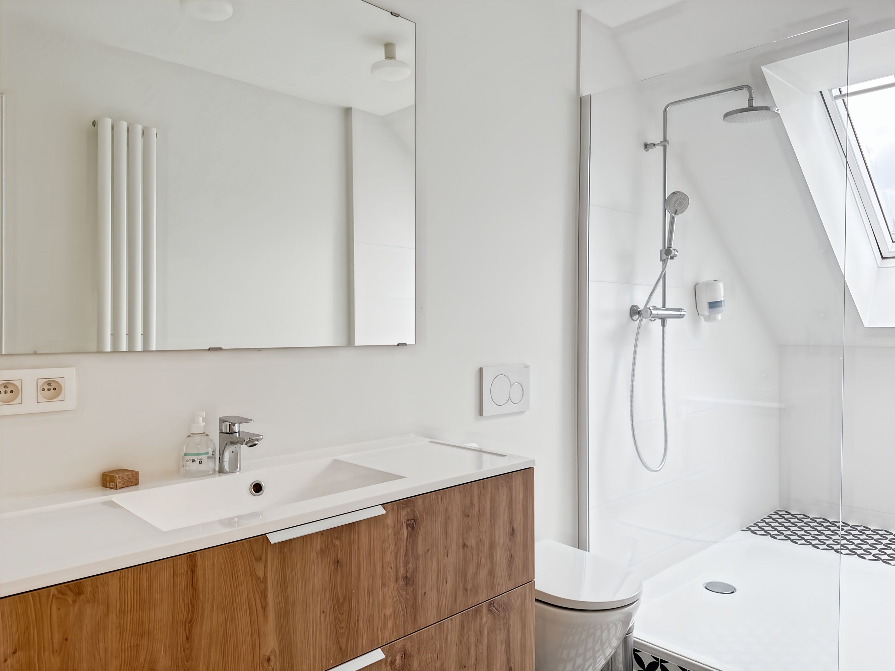 Une salle de bain moderne avec un meuble-lavabo blanc, un meuble en bois et une cabine de douche en verre.