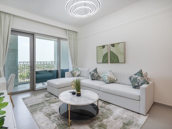 Ein modernes Wohnzimmer mit Sofa, Couchtisch und Balkon.