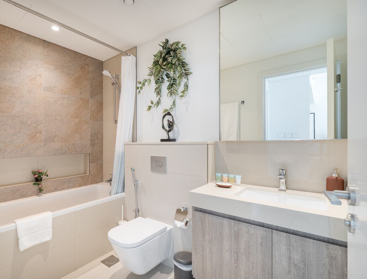 Une salle de bain moderne équipée d’une baignoire, de toilettes et d’un lavabo.
