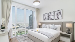 Une chambre d’hôtel moderne, dotée d’un grand lit, d’un bureau et offrant une vue sur la ville.