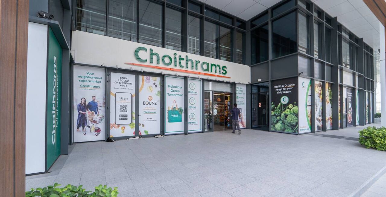 L’extérieur du supermarché Choithram, avec ses grandes baies vitrées et sa façade moderne.