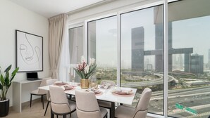 Un espace repas moderne doté d’une grande fenêtre donnant sur la ville.