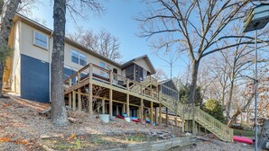 Une maison à deux étages dotée d’une terrasse en bois et d’un escalier menant à l’étage supérieur.